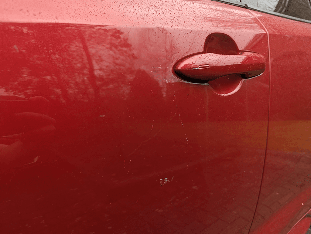 Red Corolla driver door scratches near handle record